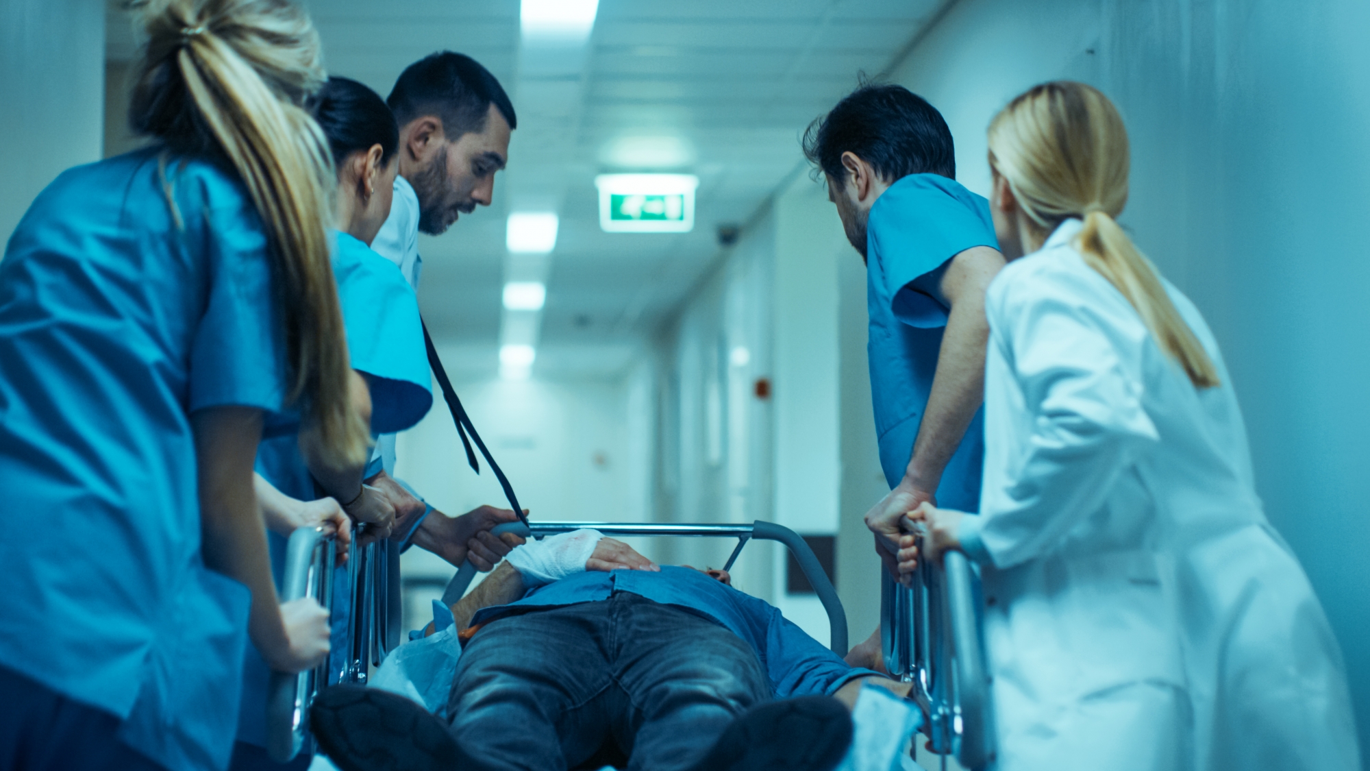 Hospital staff rushing gurney down hallway