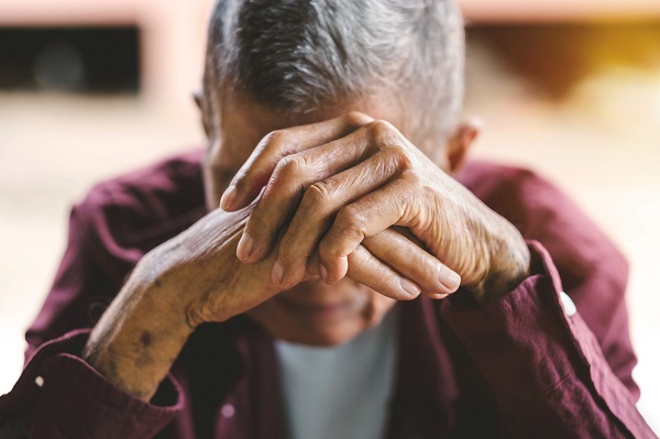 Elderly man, hands clasped, head bowed